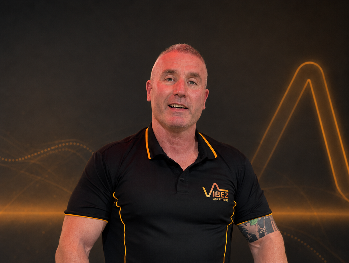 Vibez fitness trainer in black polo shirt smiling | VibeZ 24/7 Fitness