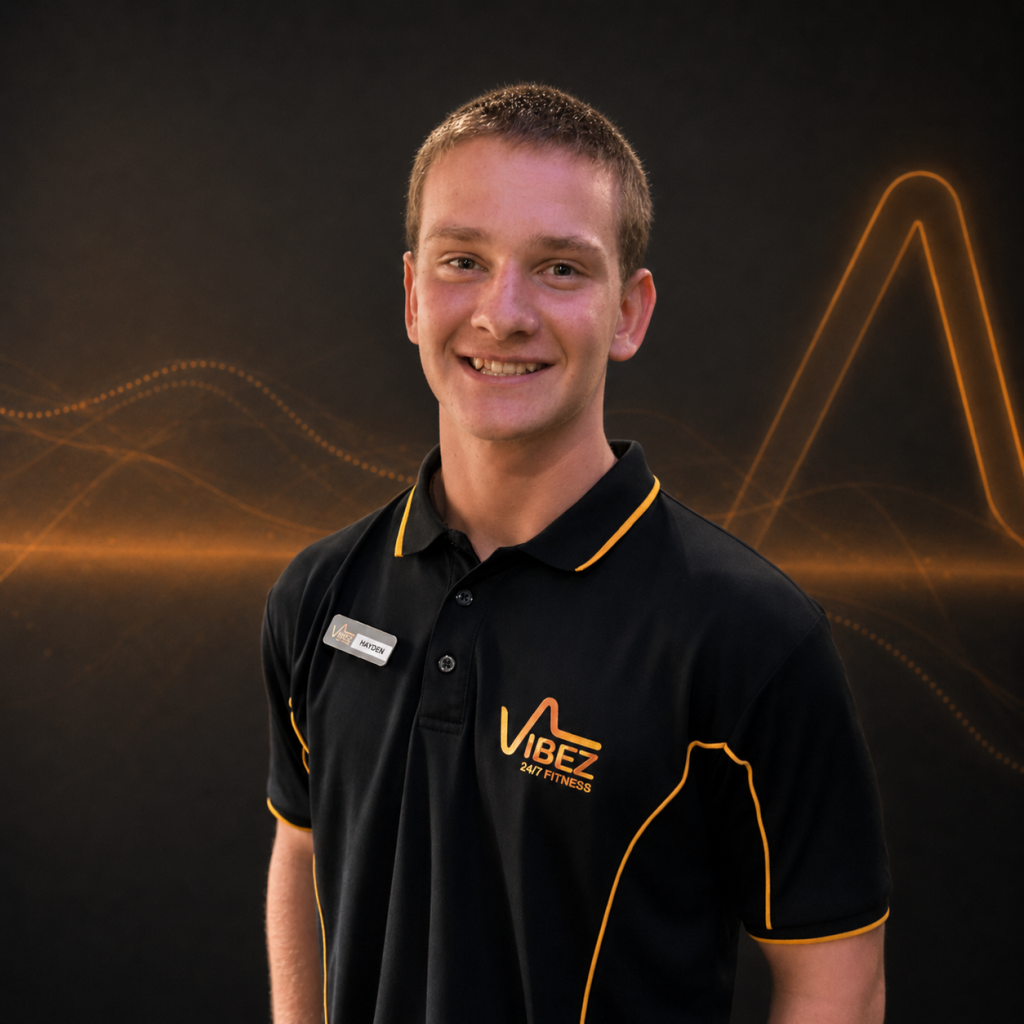 Smiling young trainer in polo shirt | VibeZ 24/7 Fitness