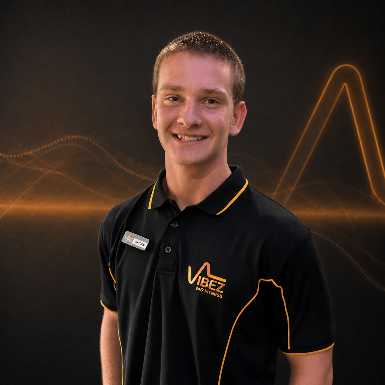 Smiling young trainer in polo shirt | VibeZ 24/7 Fitness